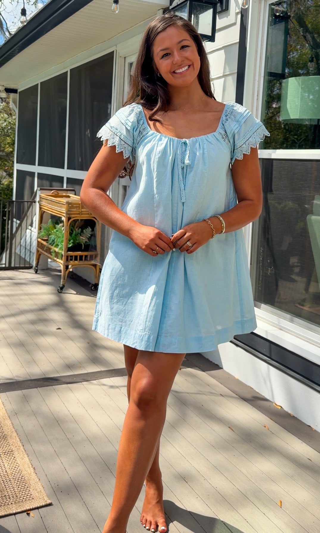 light blue linen blend mini dress with eyelet lace trim sleeves and tie neckline