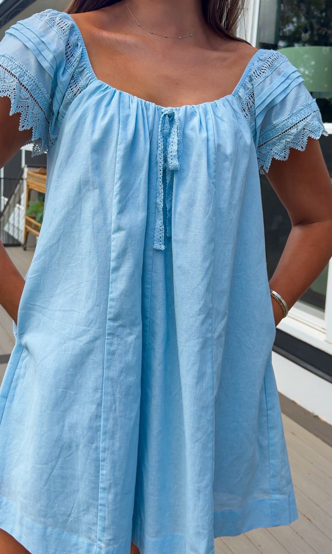 light blue linen blend mini dress with eyelet lace trim sleeves and tie neckline