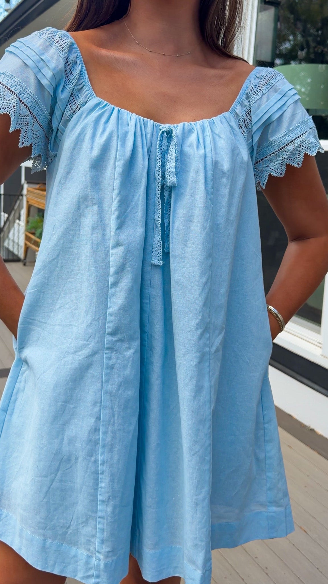 light blue linen blend mini dress with eyelet lace trim sleeves and tie neckline