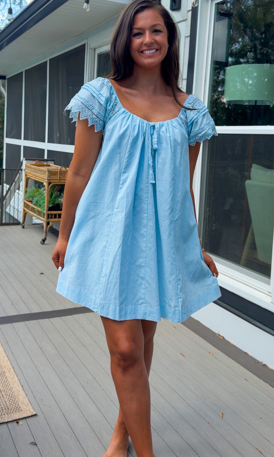 light blue linen blend mini dress with eyelet lace trim sleeves and tie neckline