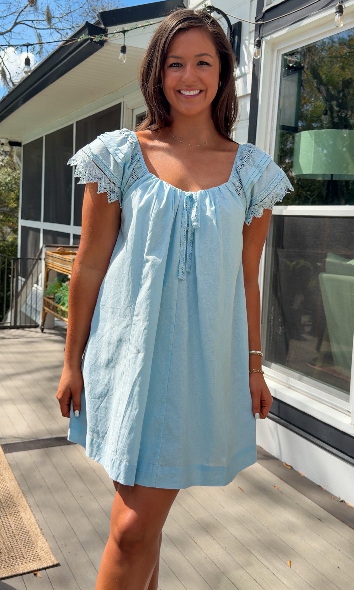 light blue linen blend mini dress with eyelet lace trim sleeves and tie neckline
