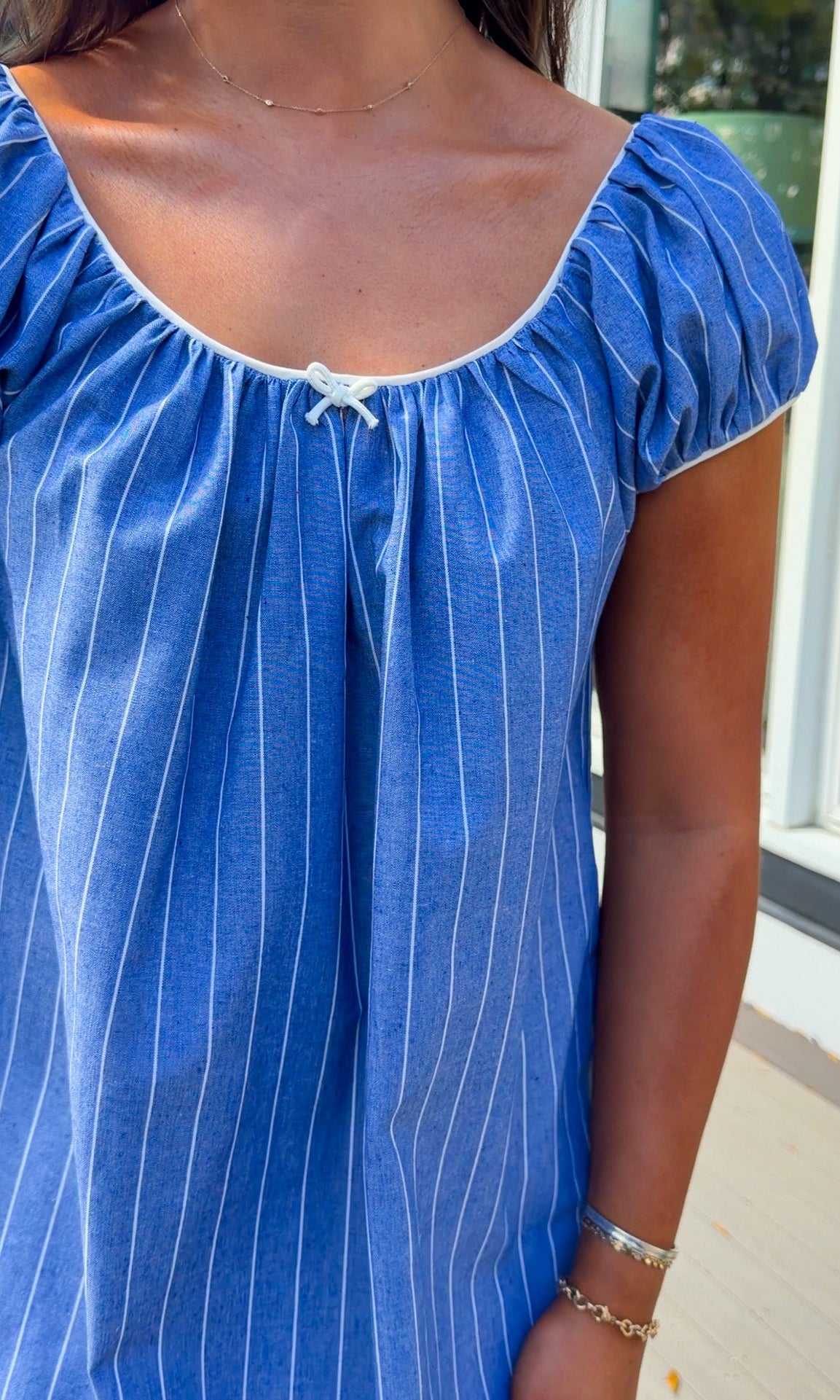 blue stripe babydoll mini dress with gathered neckline short sleeves and side pockets