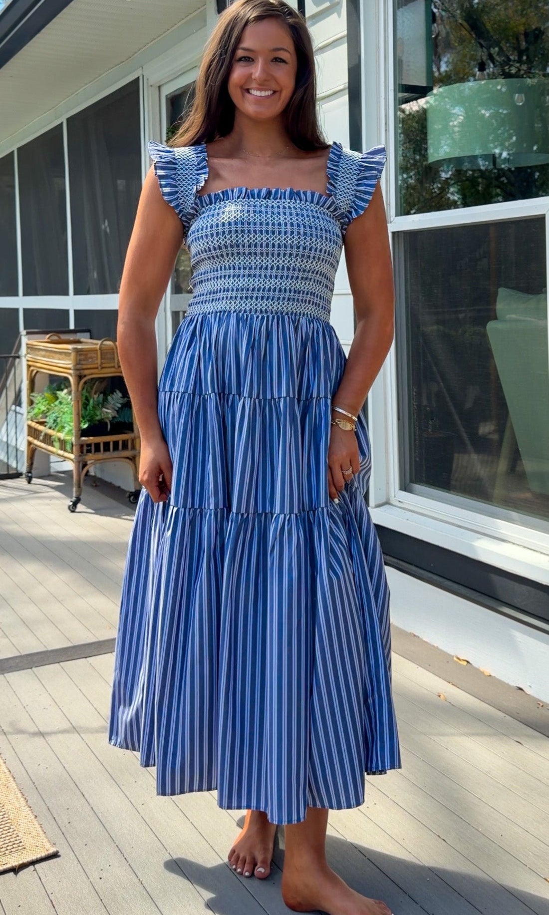 navy striped midi dress with smocked bodice ruffle sleeves and tiered skirt