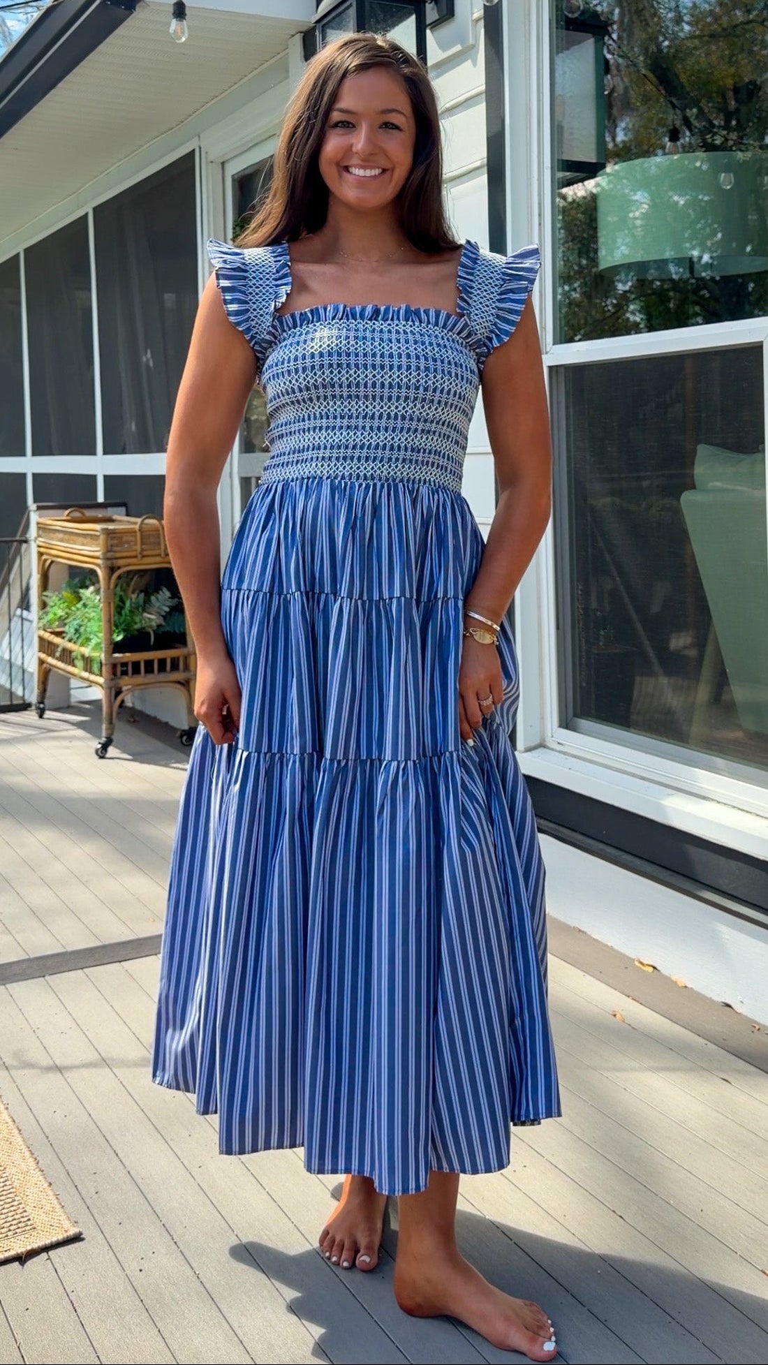 navy striped midi dress with smocked bodice ruffle sleeves and tiered skirt
