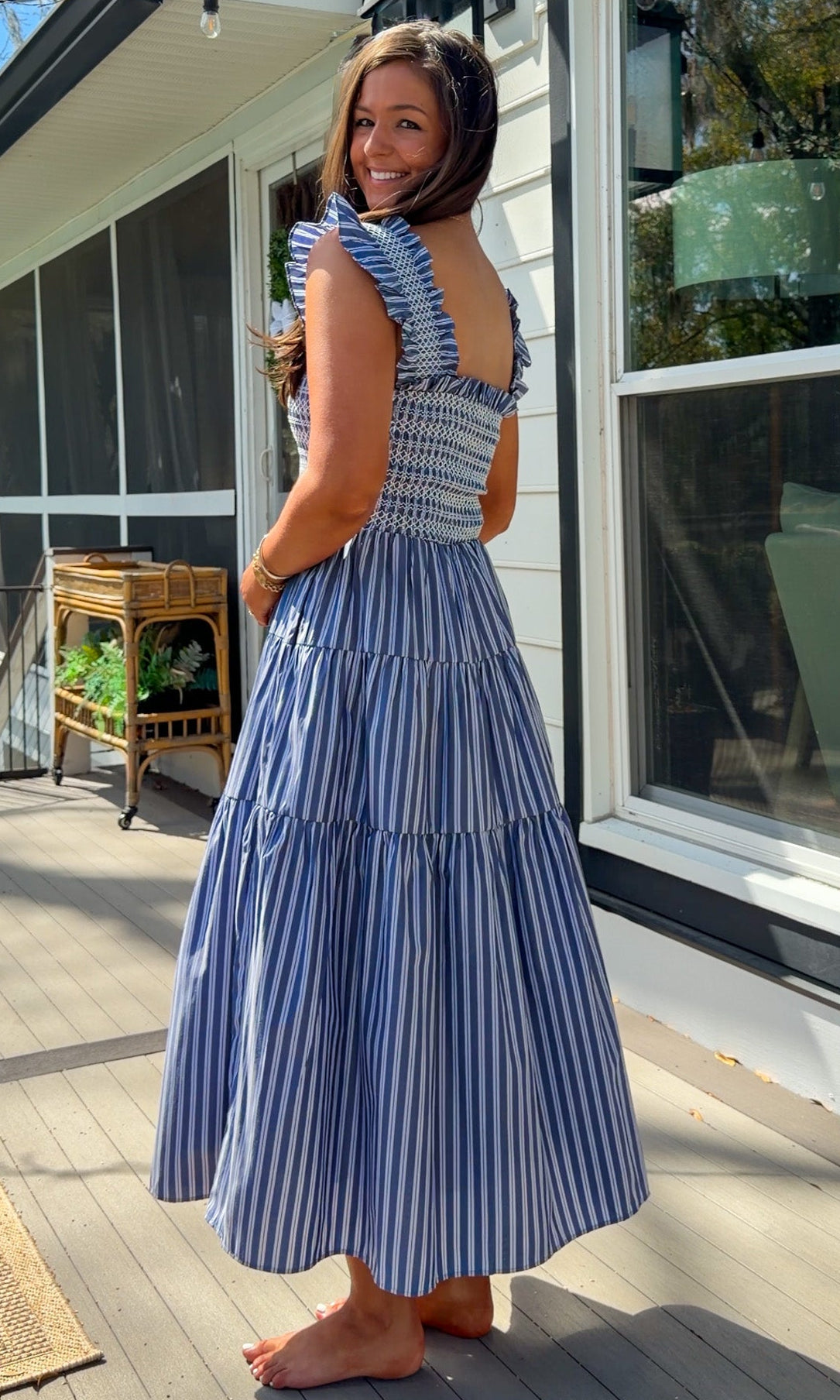 navy striped midi dress with smocked bodice ruffle sleeves and tiered skirt