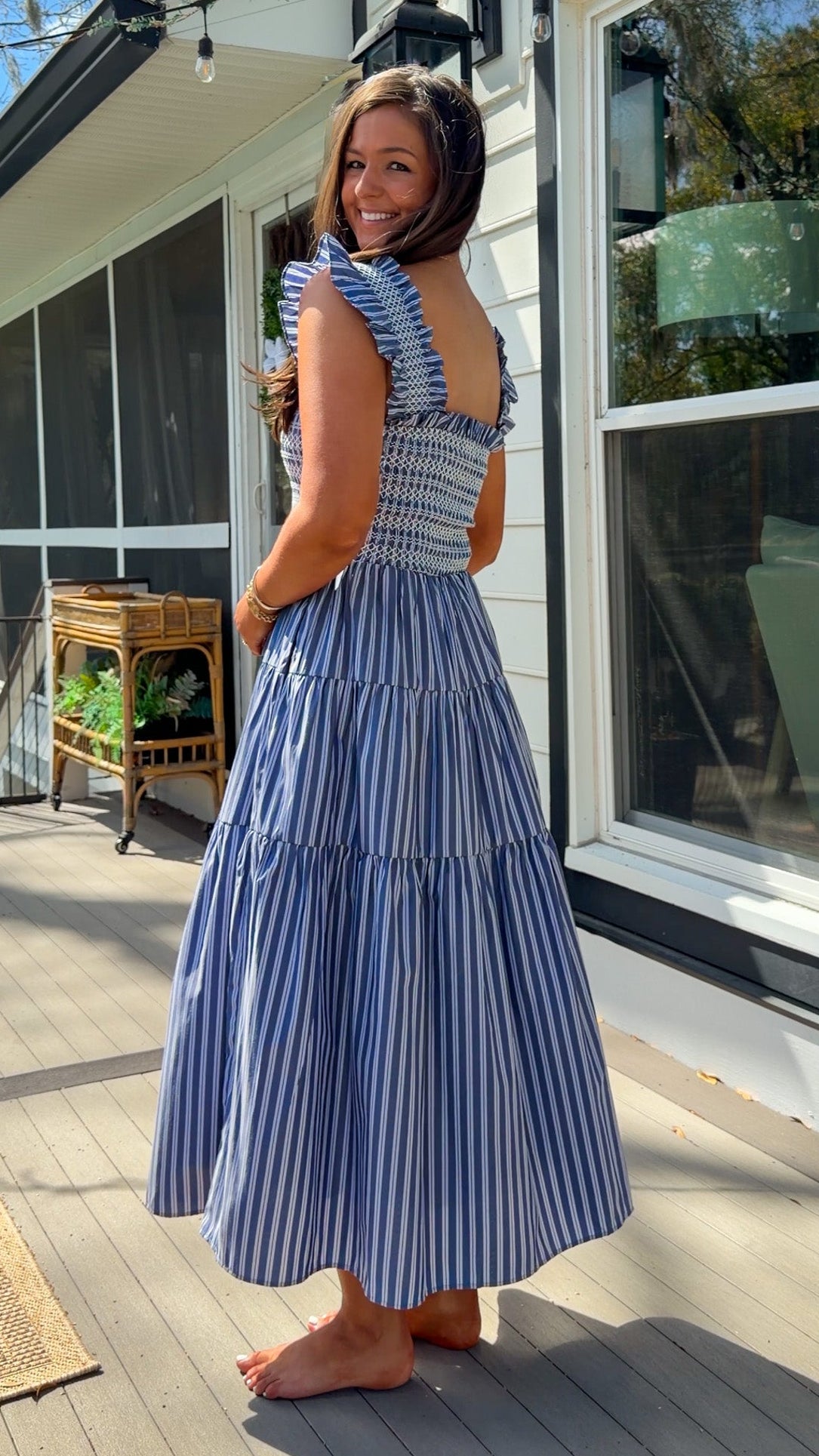 navy striped midi dress with smocked bodice ruffle sleeves and tiered skirt
