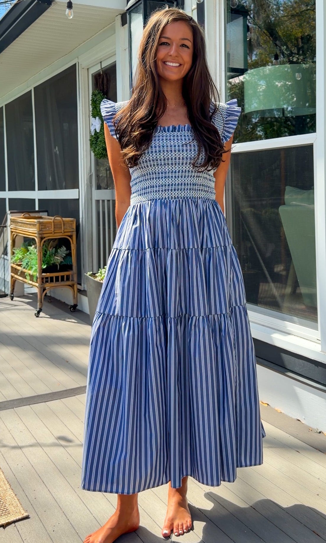 navy striped midi dress with smocked bodice ruffle sleeves and tiered skirt