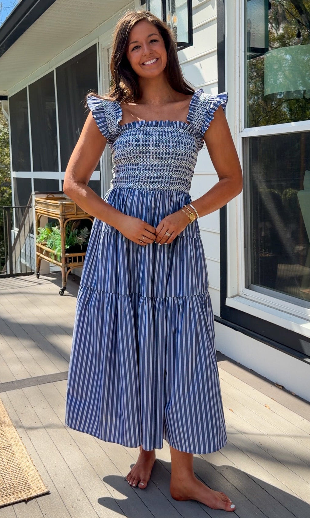 navy striped midi dress with smocked bodice ruffle sleeves and tiered skirt