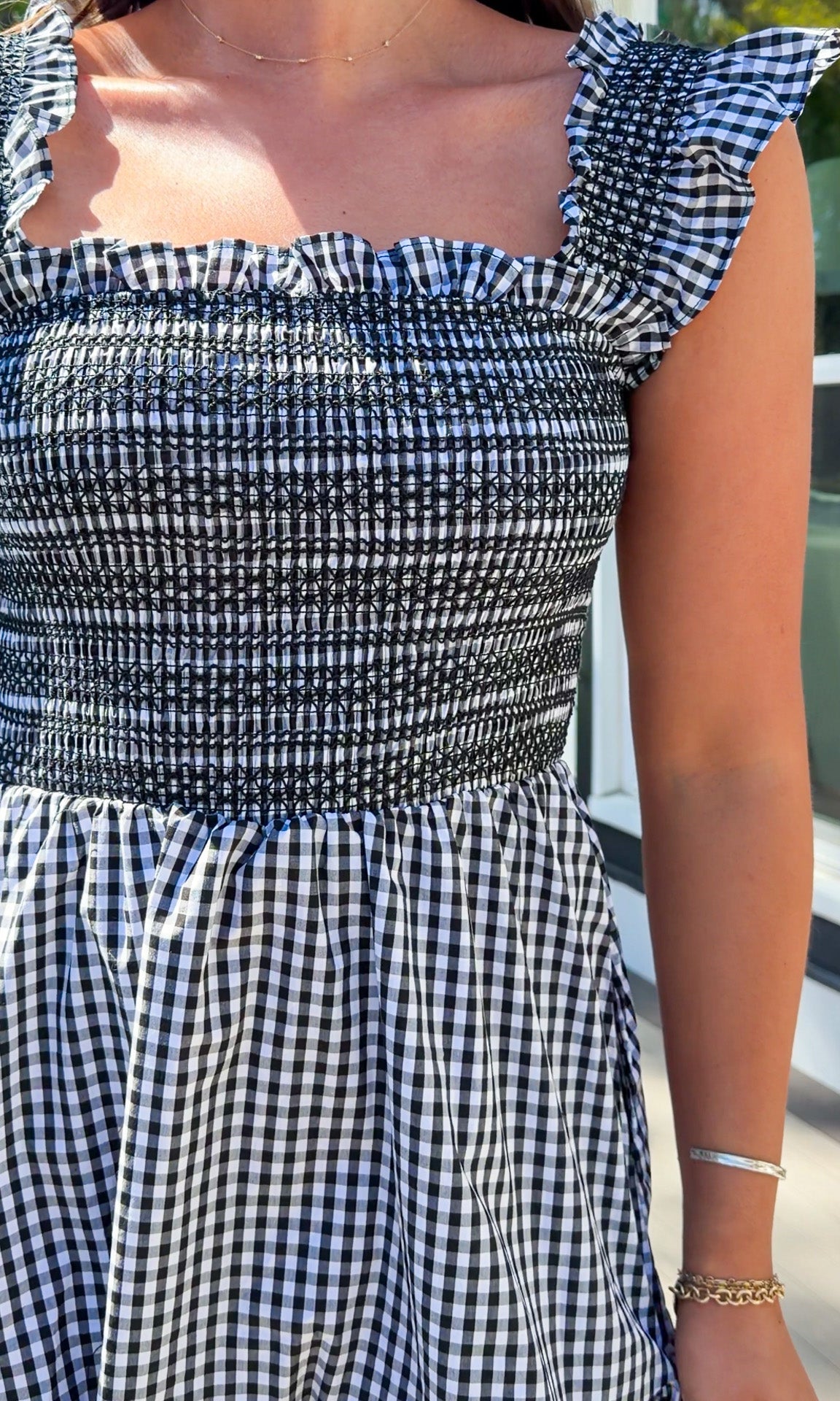 black and white gingham smocked mini dress with ruffle straps and flowy skirt and built in shorts