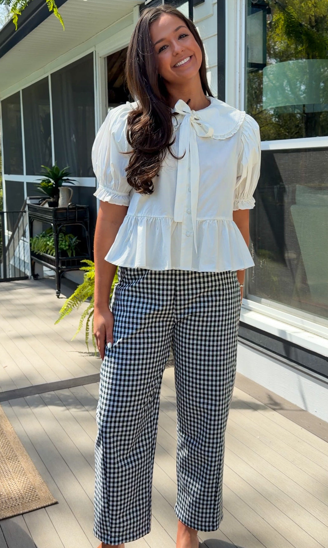 white cotton blouse with peter pan collar, puff sleeves, tie front bow and peplum hem