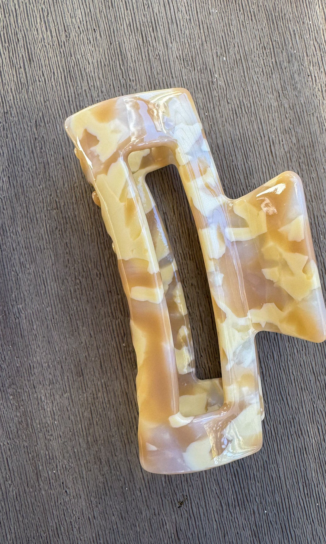 Marbled patterned hair clip on a wooden surface