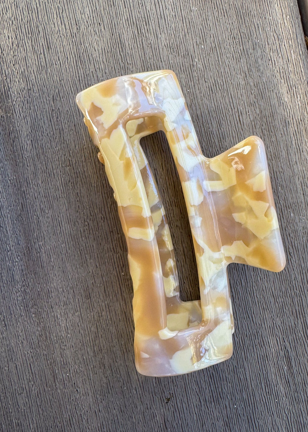 Marbled patterned hair clip on a wooden surface