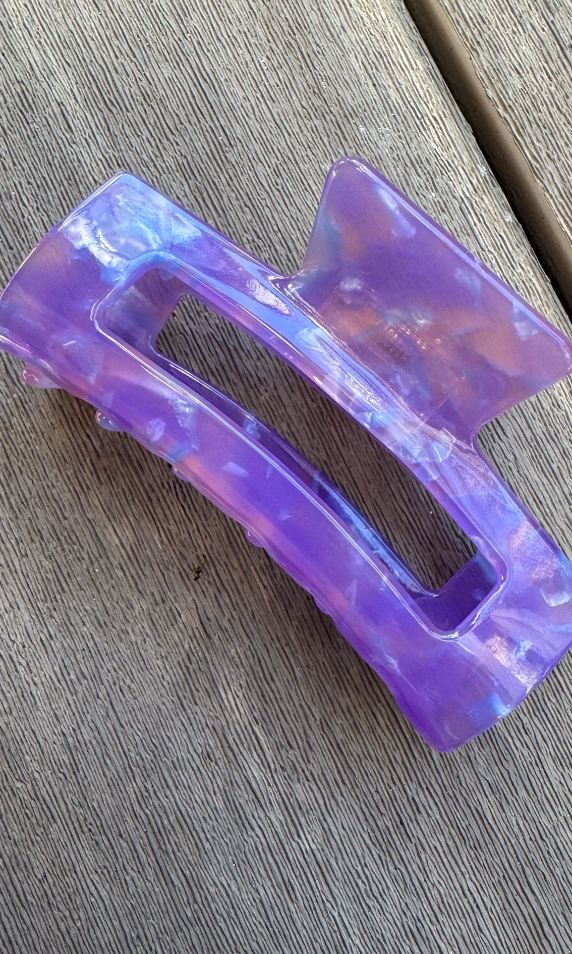 Purple hair clip on a wooden surface