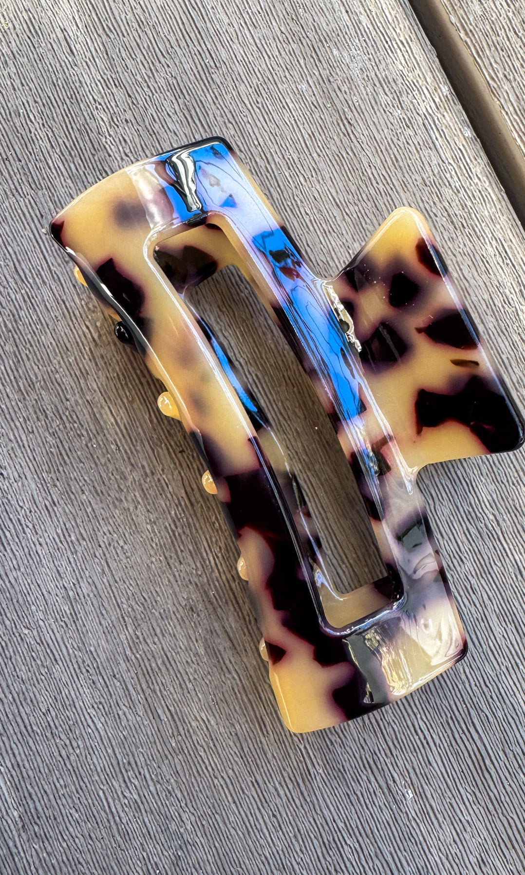 Tortoiseshell patterned hair clip on a wooden surface
