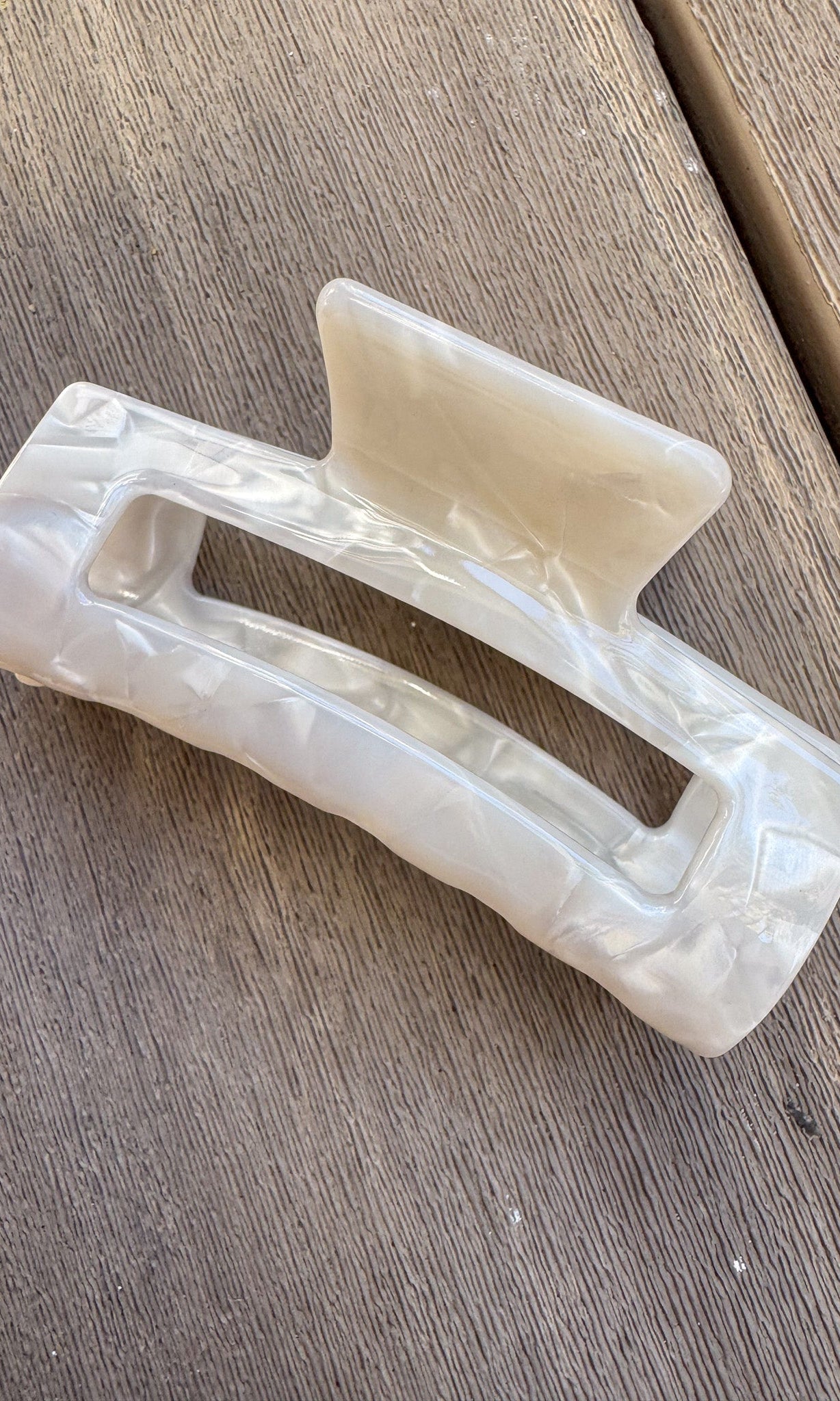 White plastic clip on a wooden surface