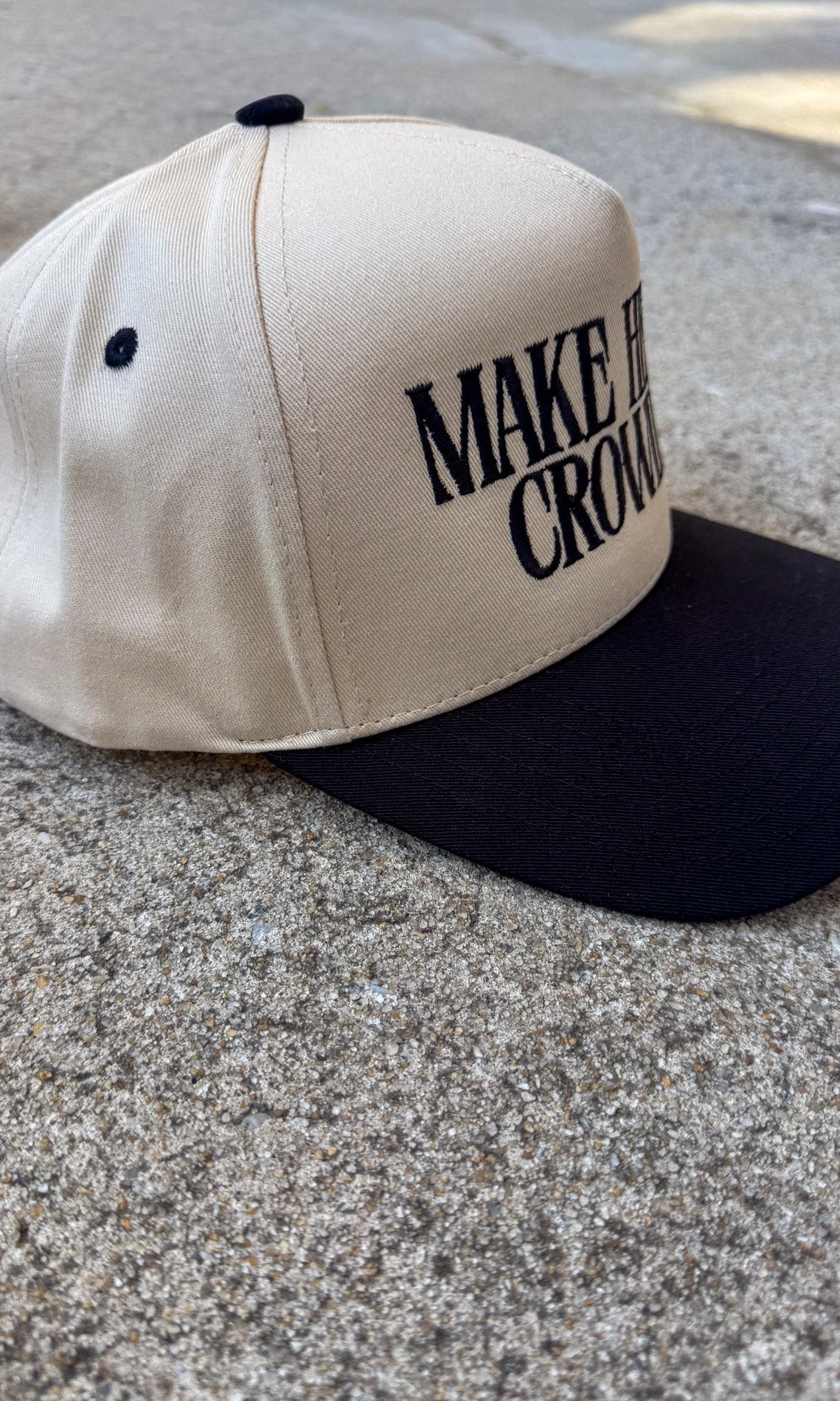 Beige and black cap with text on a concrete surface