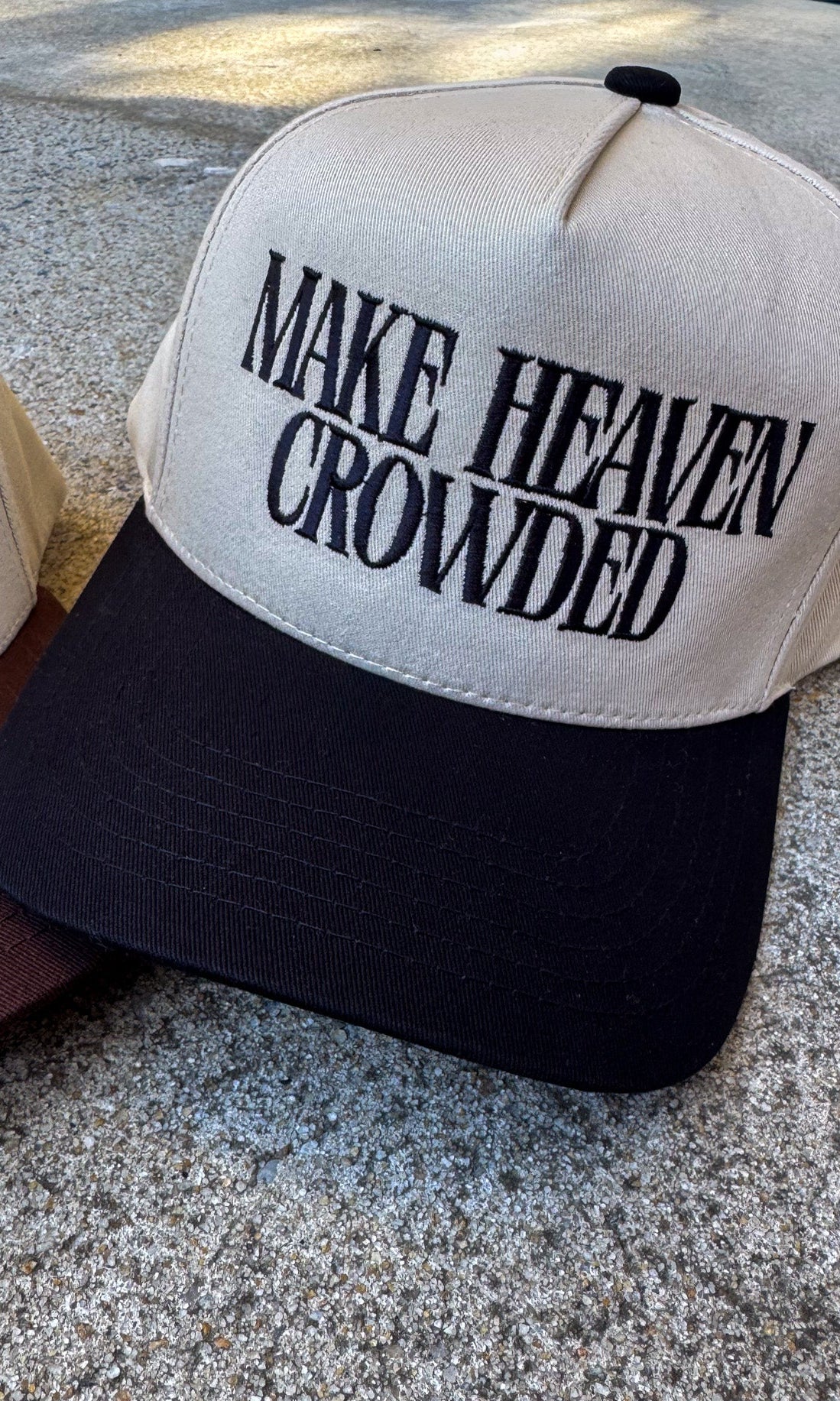 Cap with 'MAKE HEAVEN CROWDED' text on a textured surface