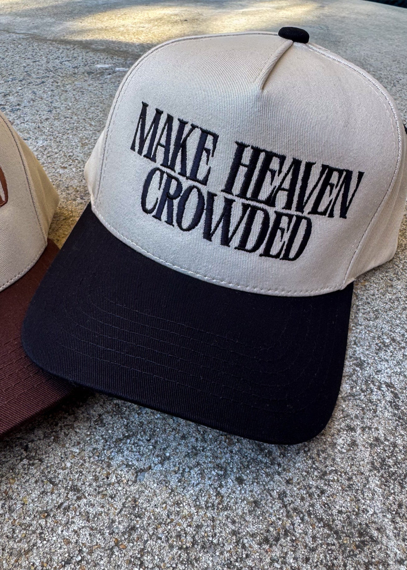 Cap with 'MAKE HEAVEN CROWDED' text on a textured surface