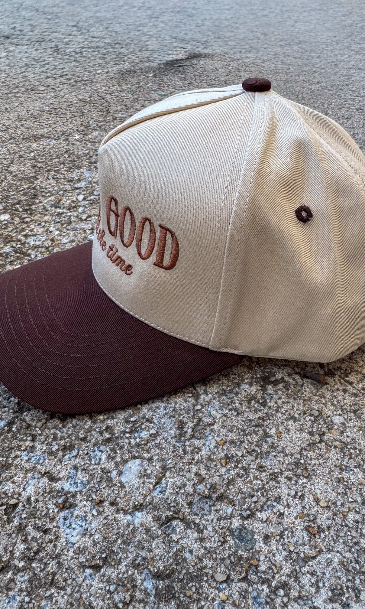 Cap with 'God is Good All the time' text on a concrete surface, trucker hat, christian trucker hat