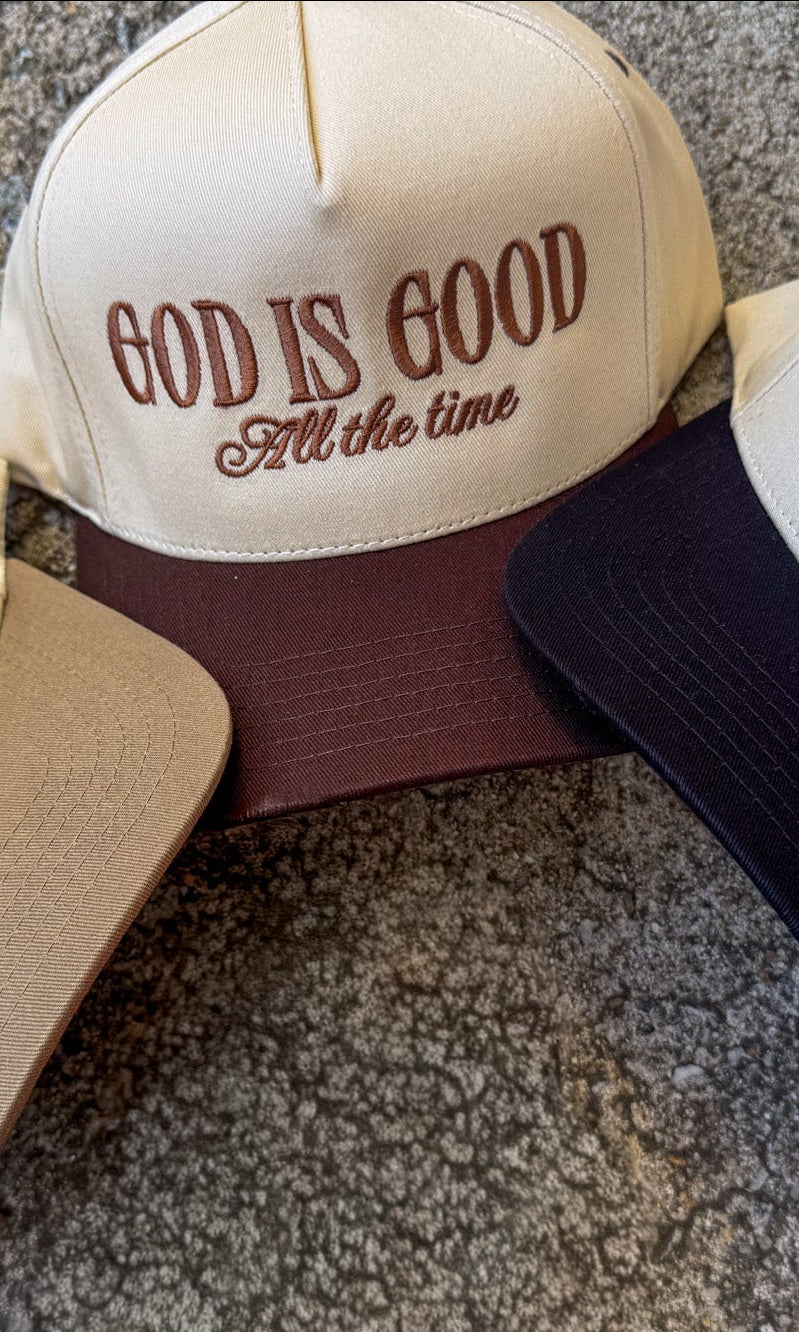 Cap with 'God is Good All the time' text on a concrete surface, trucker hat, christian trucker hat, hat with Just a Girl who loves Jesus, and Make Heaven Crowded. embroidered trucker hats