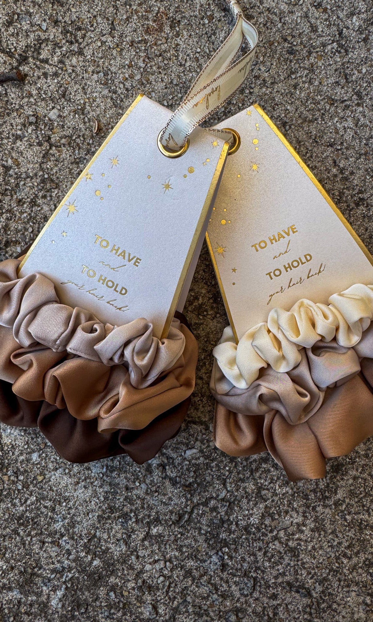 Pair of scrunchies with matching tags on a textured surface