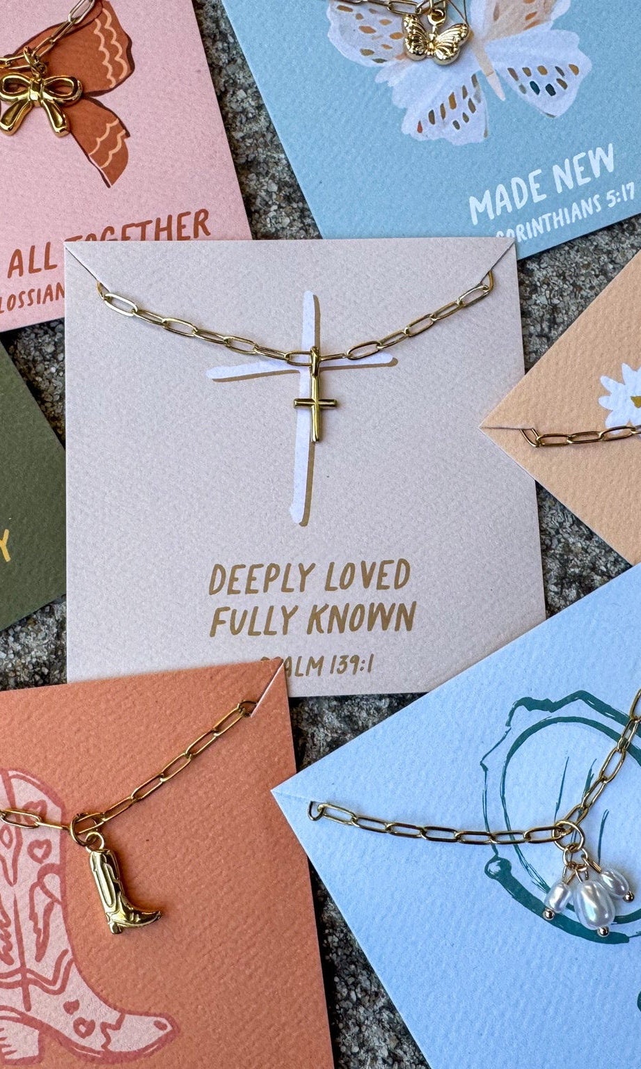 Collection of necklaces on cards with various designs and text.