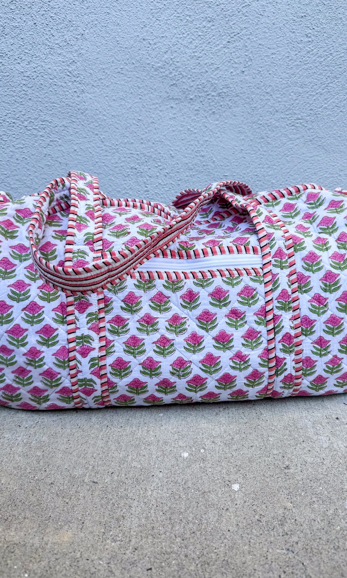 Floral patterned duffel bag on a concrete surface