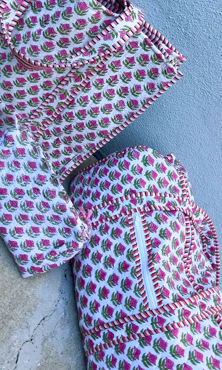 Set of patterned fabric pieces on a concrete surface with a light blue wall background