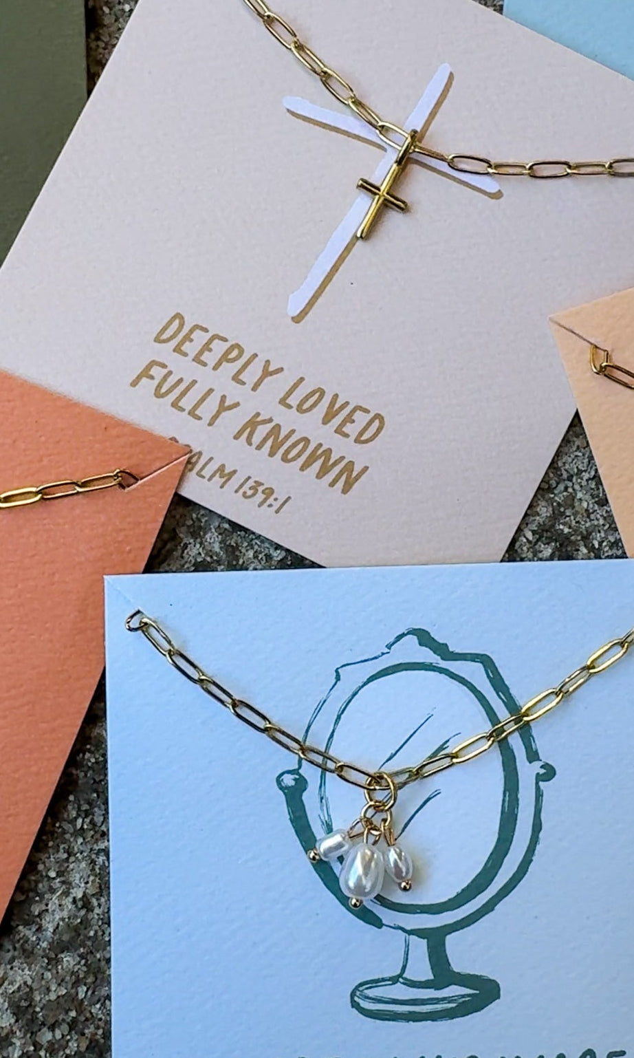 Gold necklace with a cross pendant on a card with text and other cards in the background.