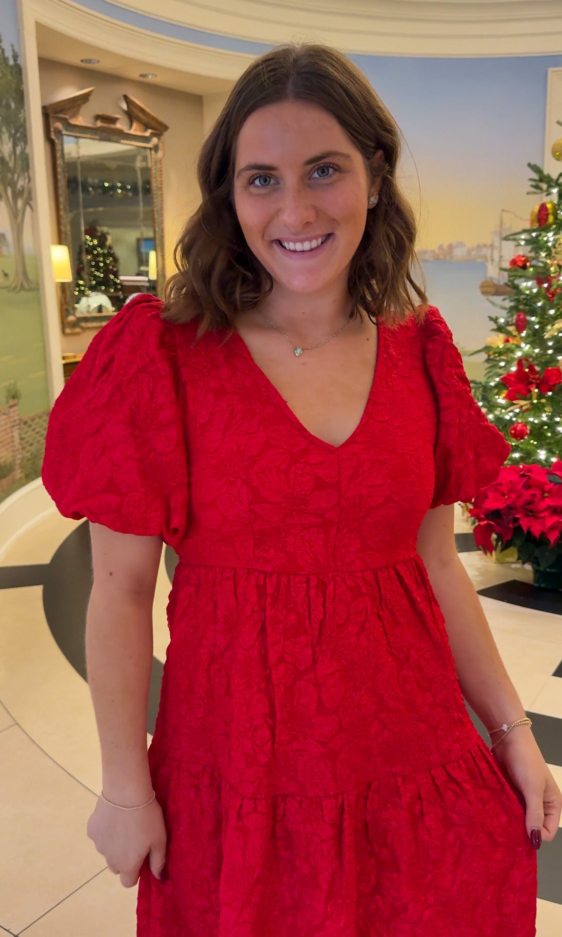 red jacquard maxi dress with puff sleeves and tiered skirt bottom and open back tie bow v neck holiday christmas dress closeup