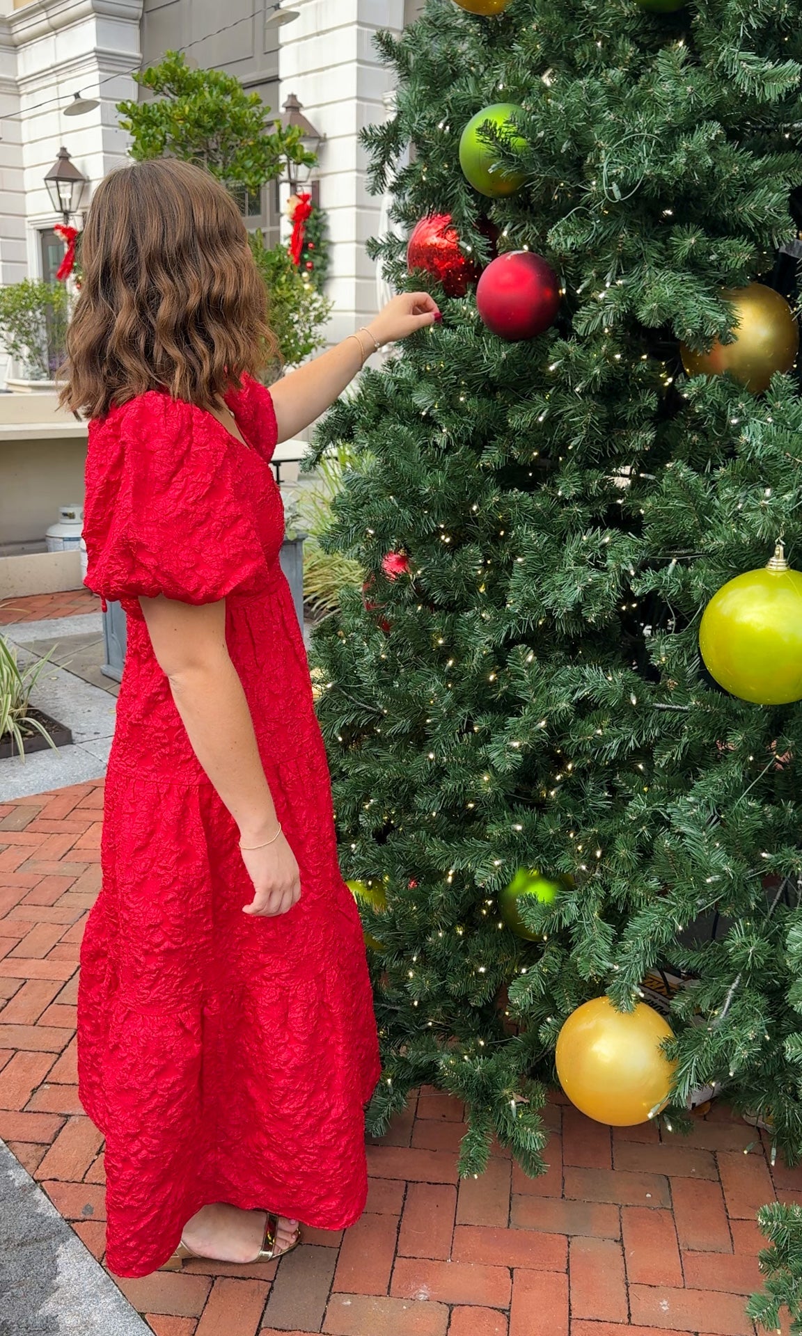 red jacquard maxi dress with puff sleeves and tiered skirt bottom and open back tie bow v neck holiday christmas dress