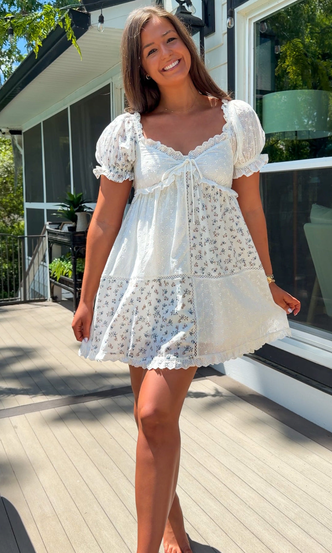 cream floral mini dress with eyelet lace, puff sleeves, scalloped neckline, and front tie detail