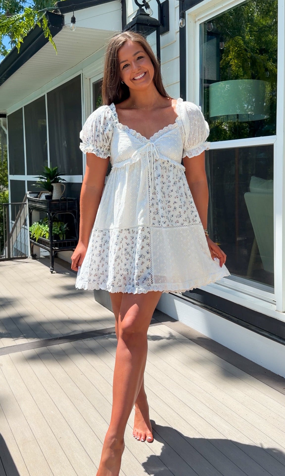 cream floral mini dress with eyelet lace, puff sleeves, scalloped neckline, and front tie detail