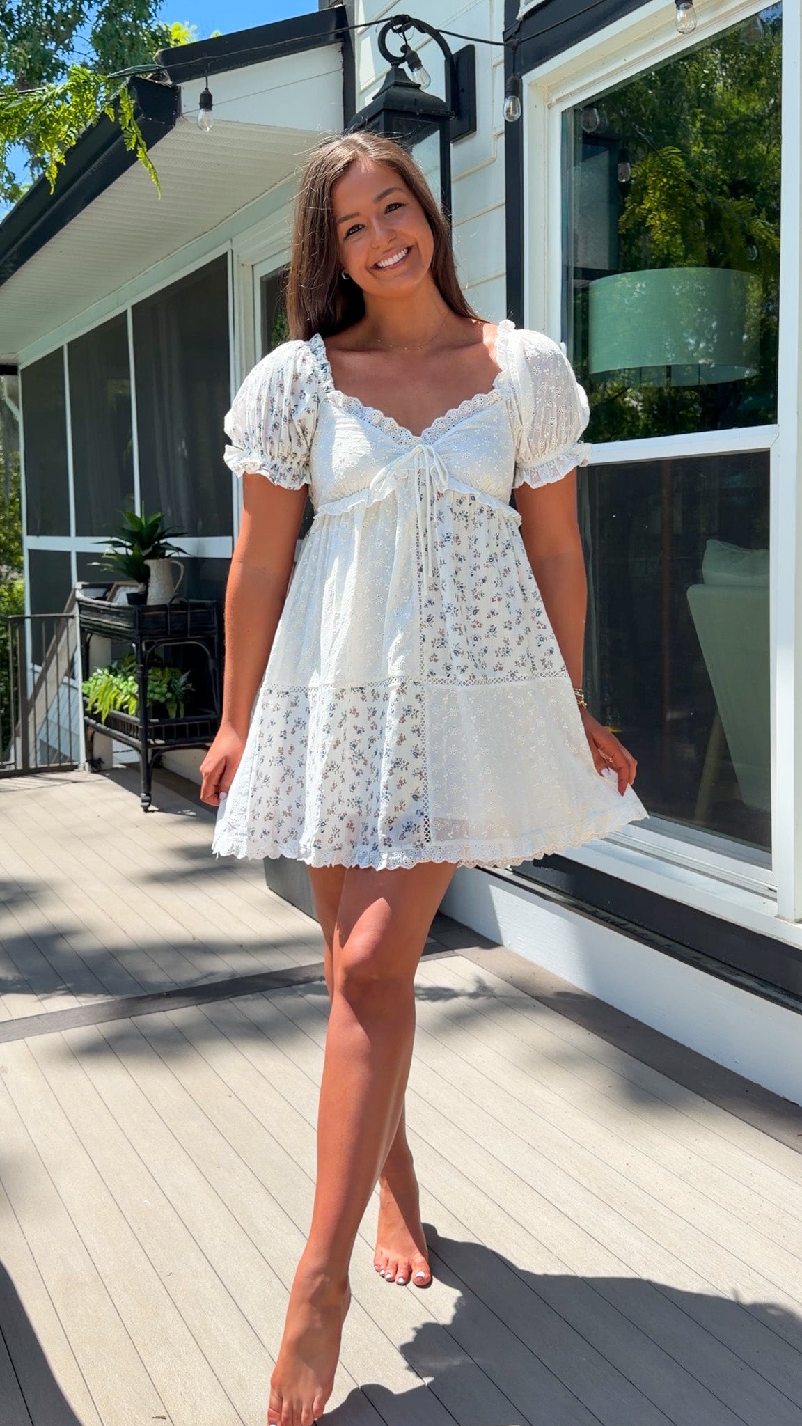 cream floral mini dress with eyelet lace, puff sleeves, scalloped neckline, and front tie detail