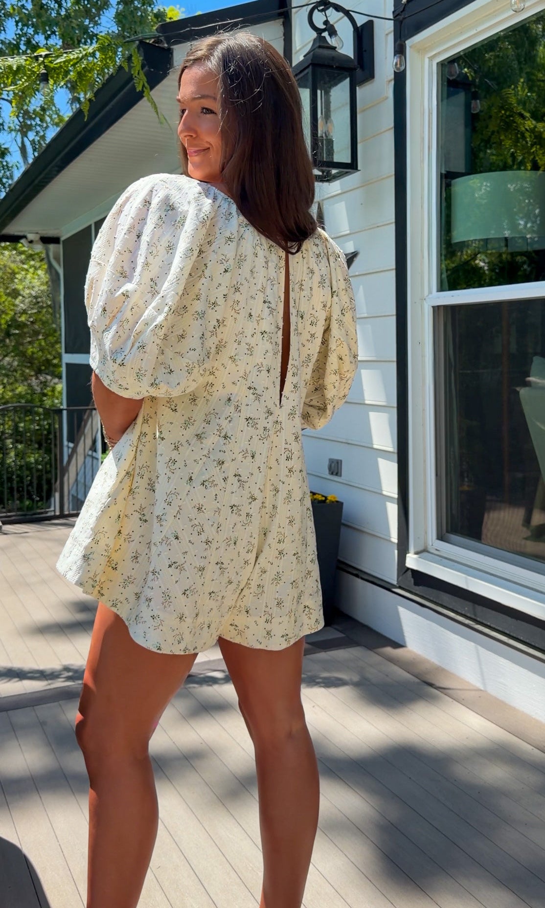 cream floral romper with puff sleeves and green tie neckline, flowy fit with built-in shorts
