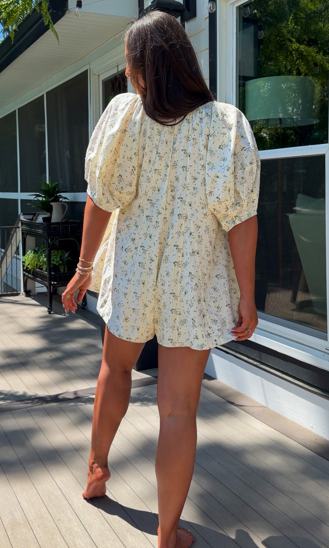 cream floral romper with puff sleeves and green tie neckline, flowy fit with built-in shorts