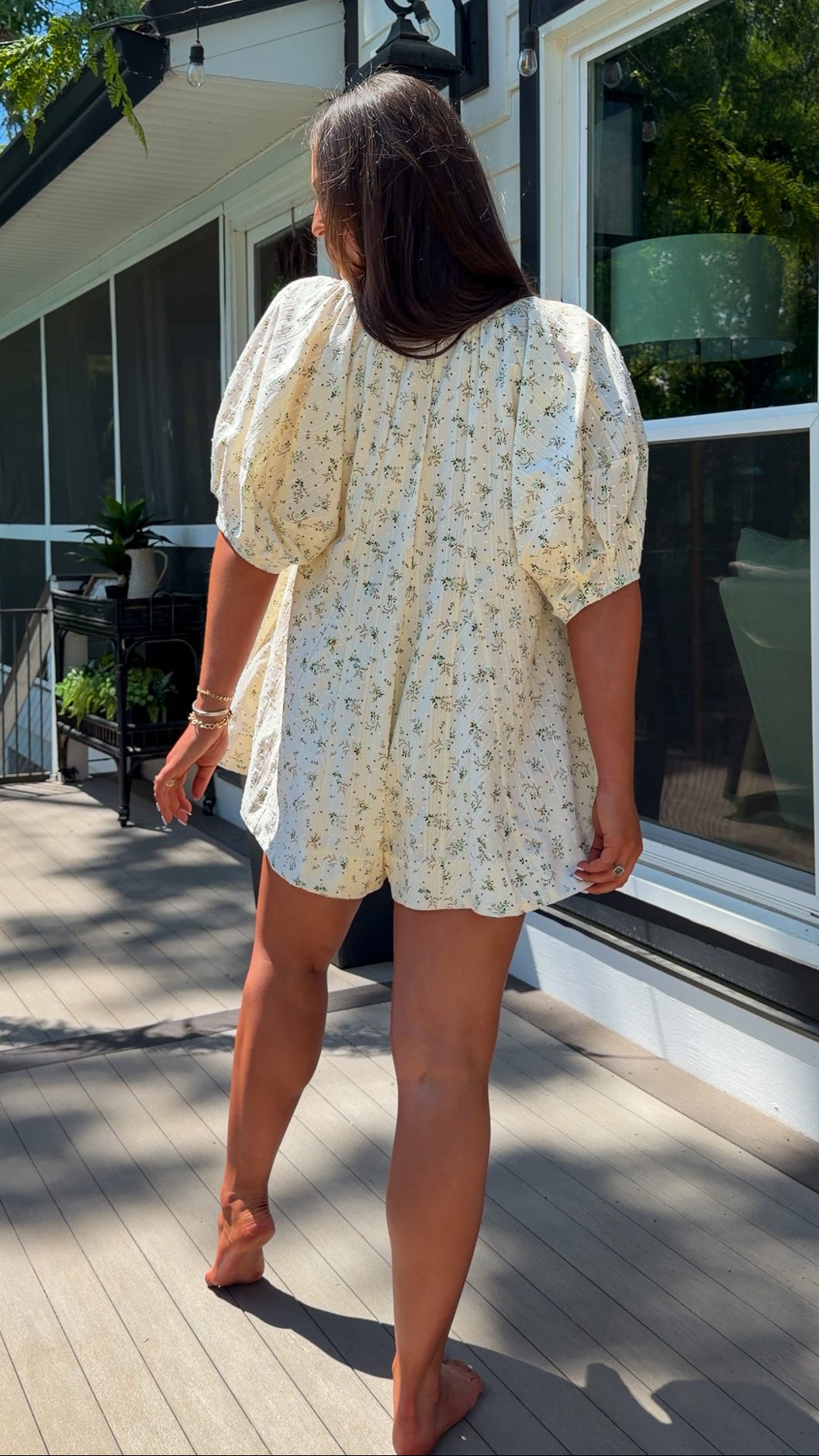 cream floral romper with puff sleeves and green tie neckline, flowy fit with built-in shorts