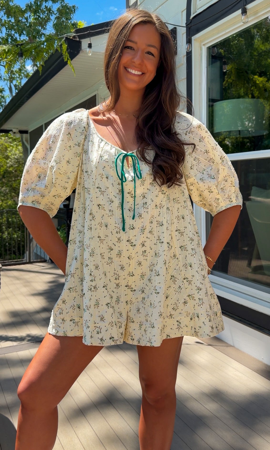 cream floral romper with puff sleeves and green tie neckline, flowy fit with built-in shorts