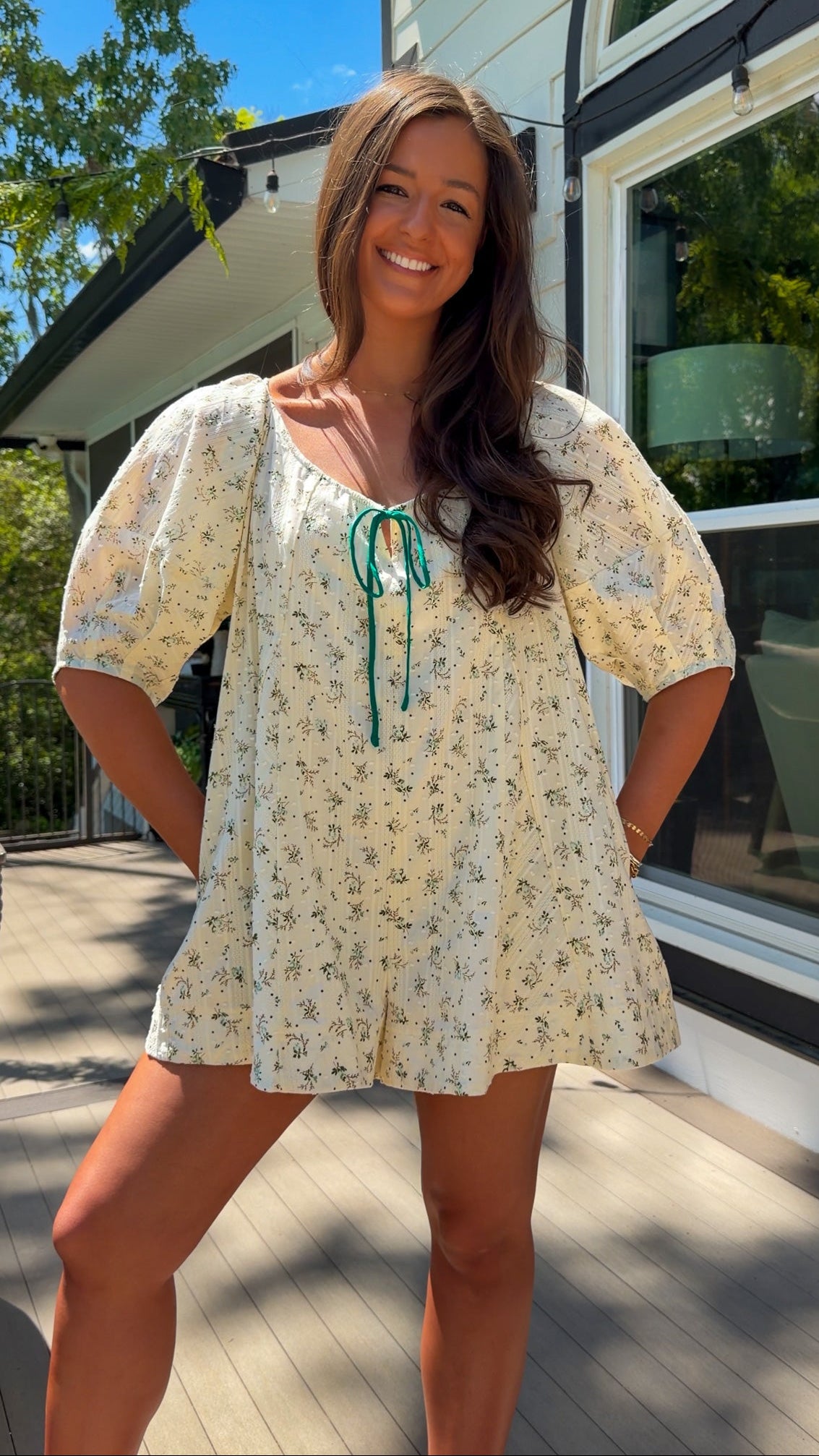 cream floral romper with puff sleeves and green tie neckline, flowy fit with built-in shorts