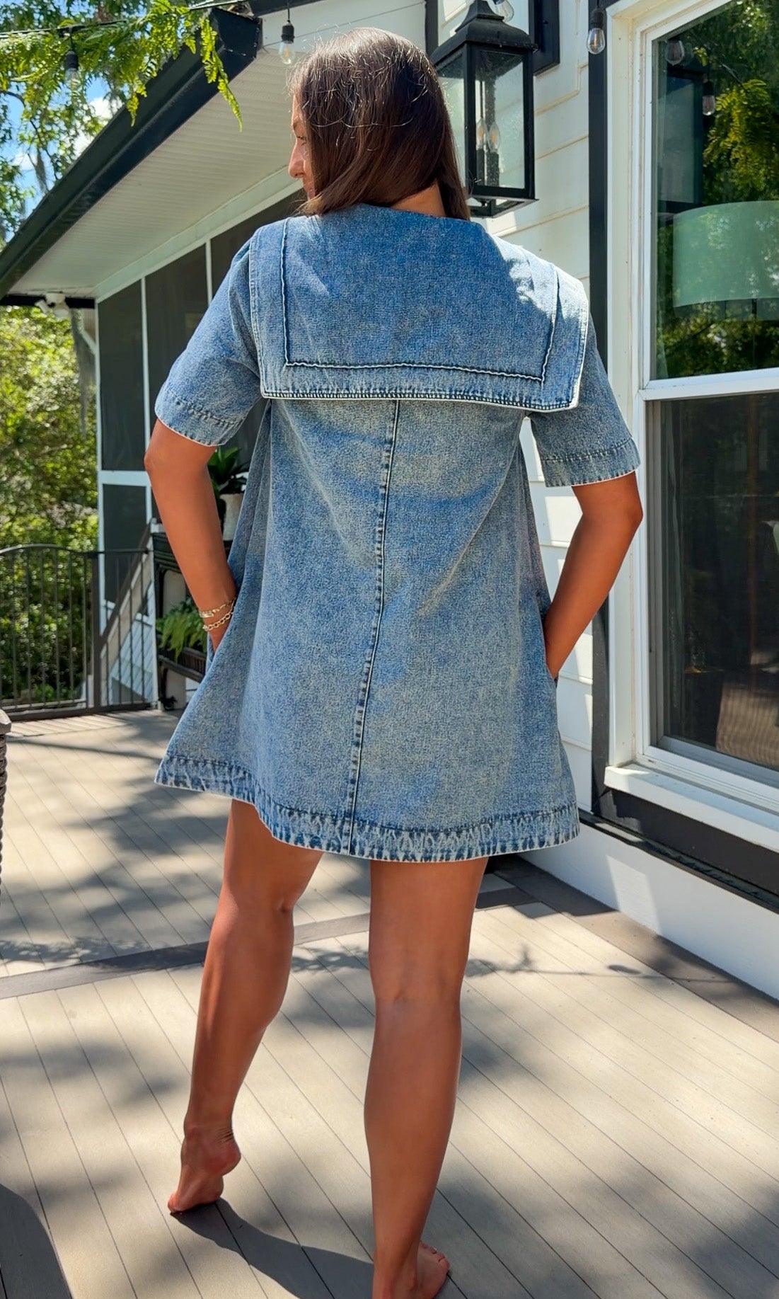 light wash denim mini dress with oversized collar, tie front detail, short sleeves, and slightly oversized fit