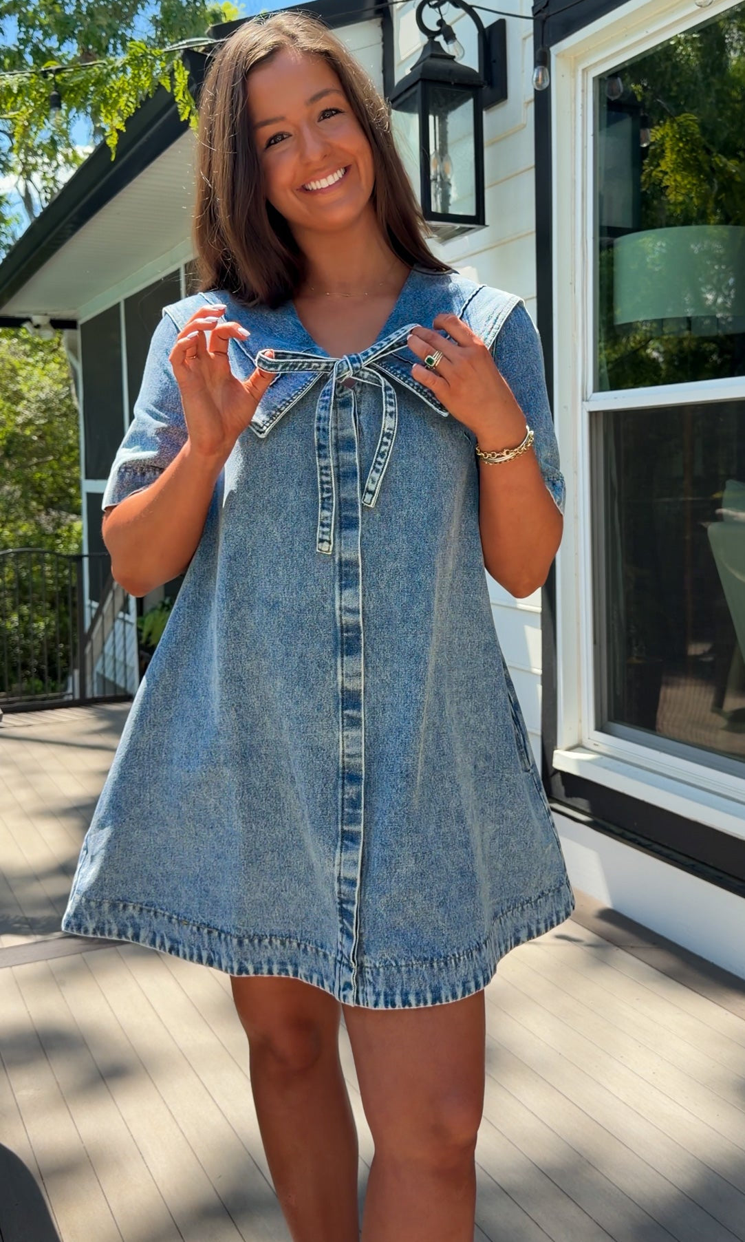 light wash denim mini dress with oversized collar, tie front detail, short sleeves, and slightly oversized fit