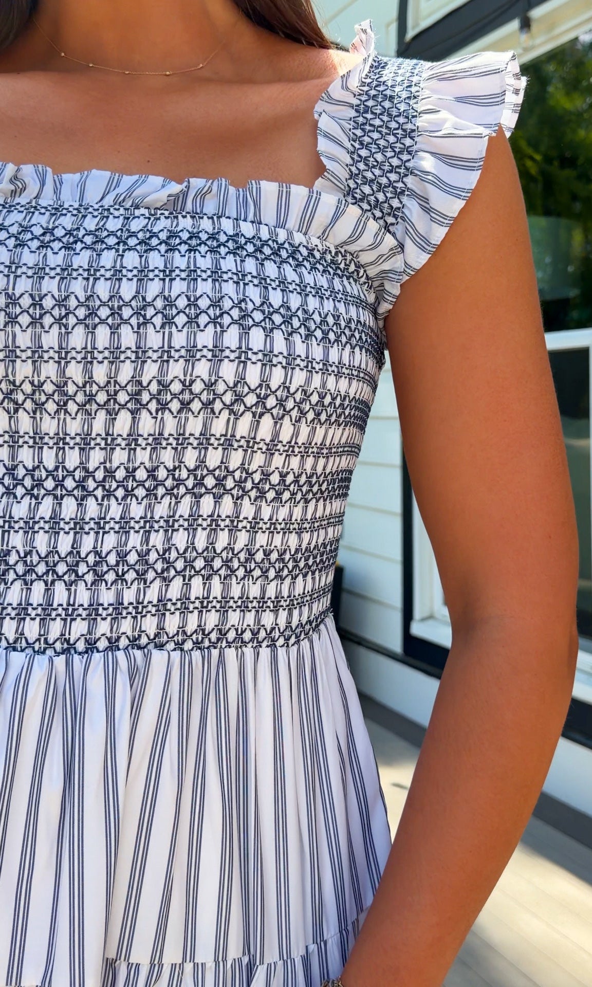 white and navy striped midi dress with smocked bodice, ruffle straps, and tiered skirt