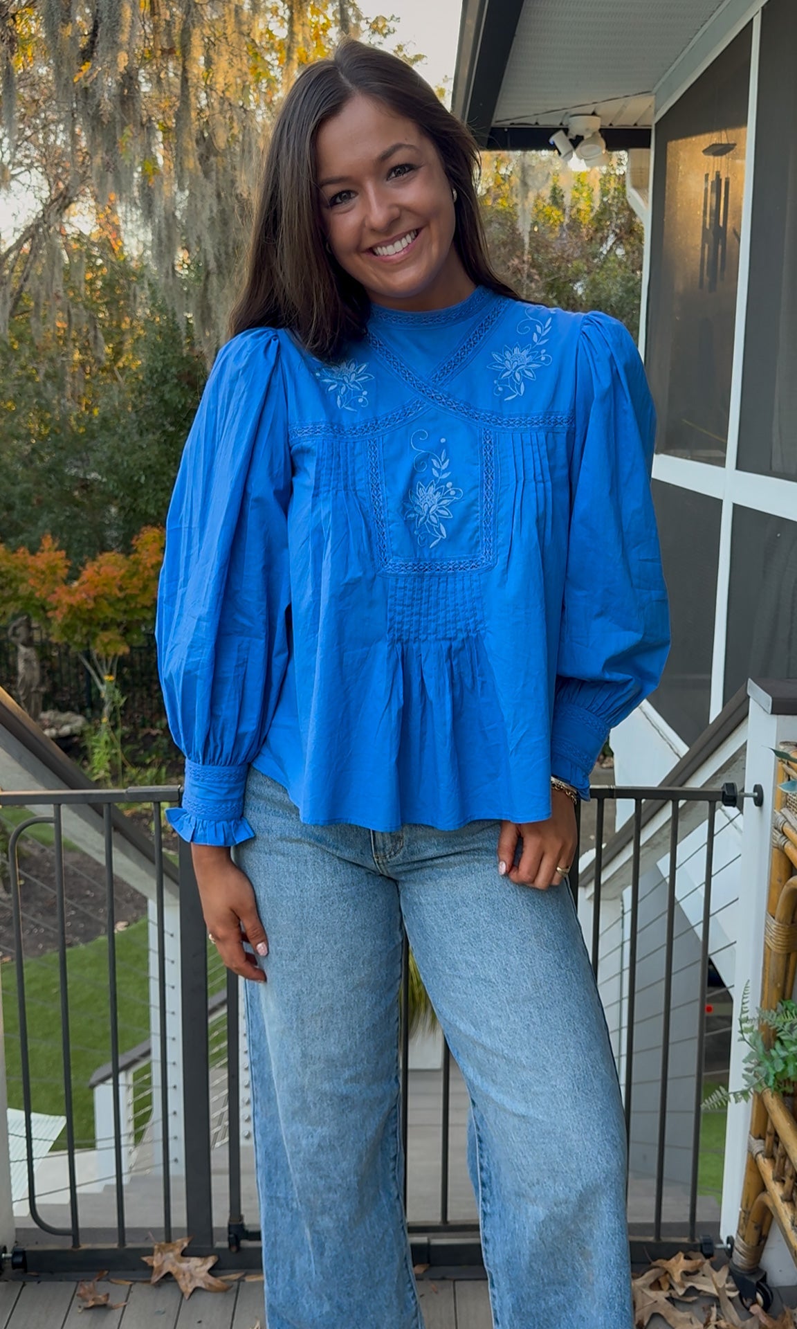 Azure blue embroidered blouse with puff sleeves and relaxed fit.