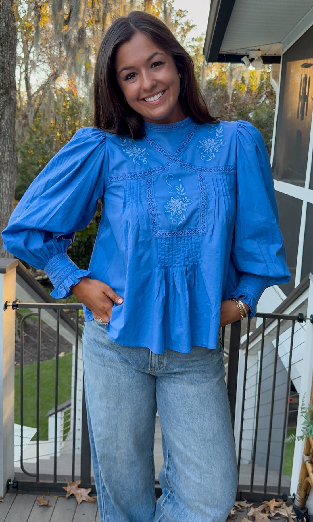 Azure blue embroidered blouse with puff sleeves and relaxed fit.