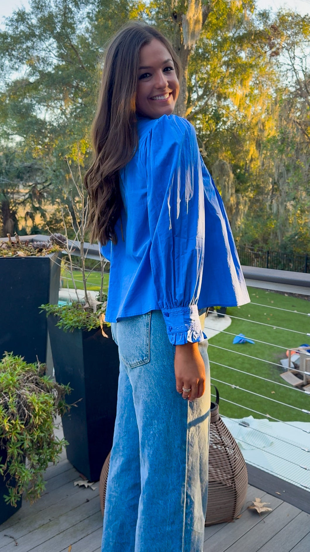 Azure blue embroidered blouse with puff sleeves and relaxed fit.