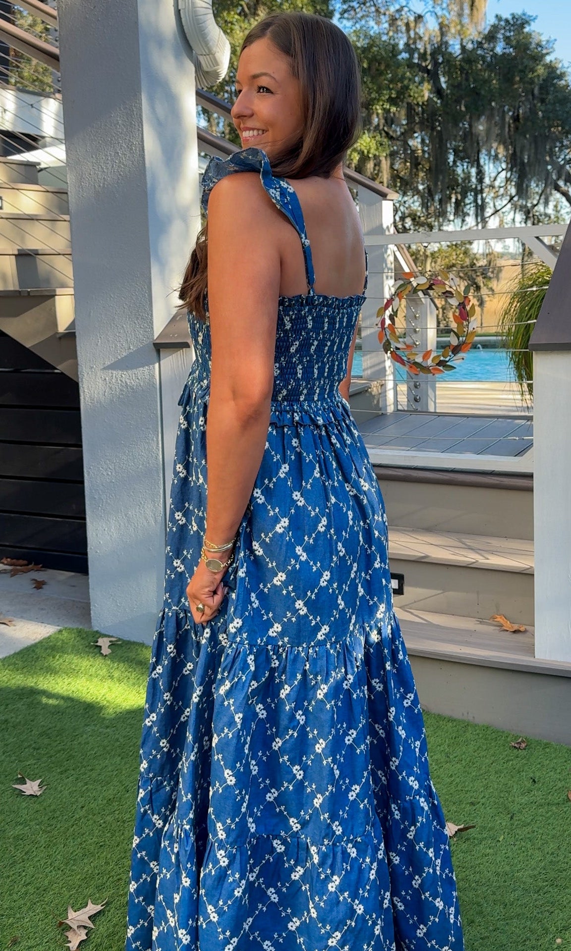 Denim blue and off-white floral tiered maxi dress with smocked bodice and flutter straps.