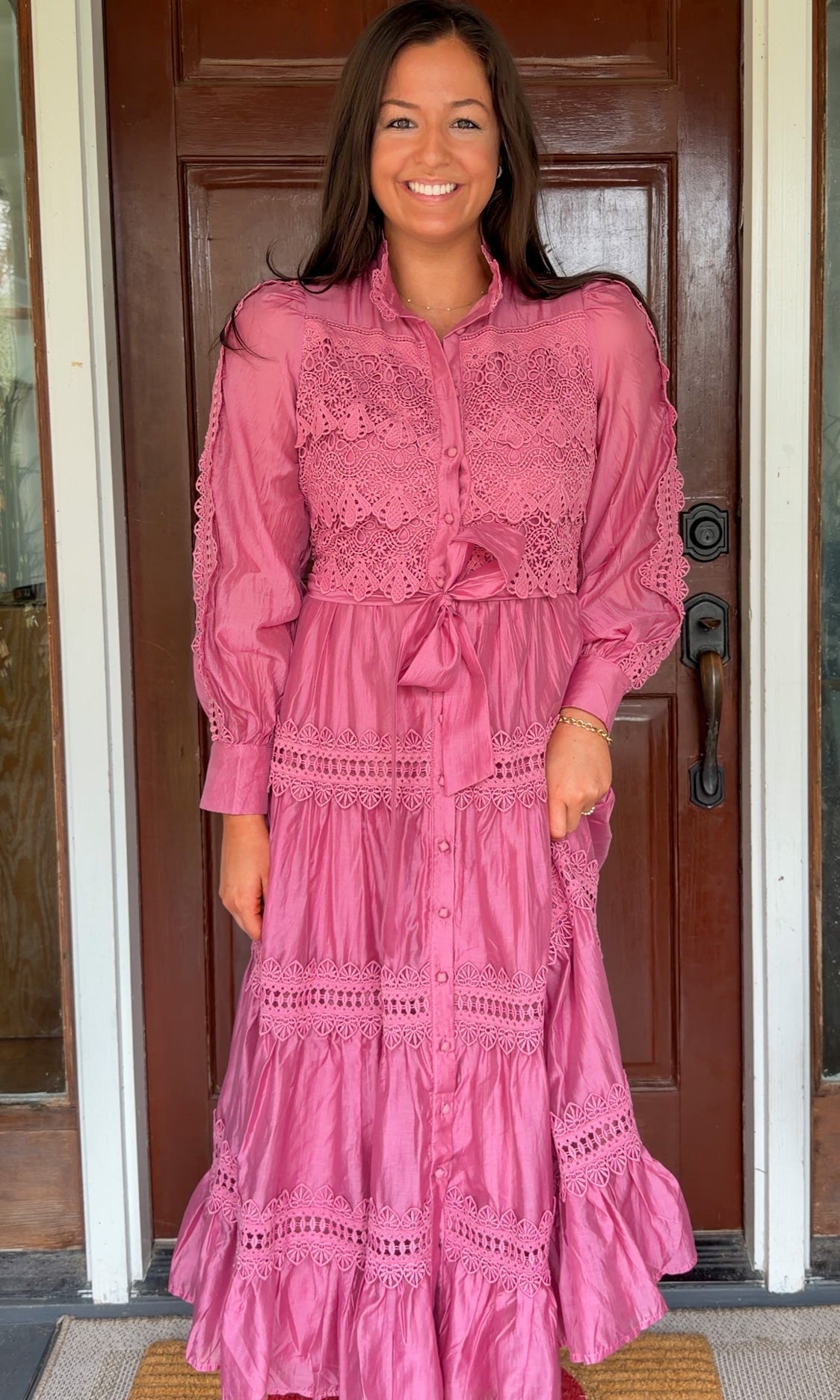 a satin midi dress with crochet lace panels, button-down front, long sleeves, and a self-tie waist in a soft plum color. pink mauve high neck