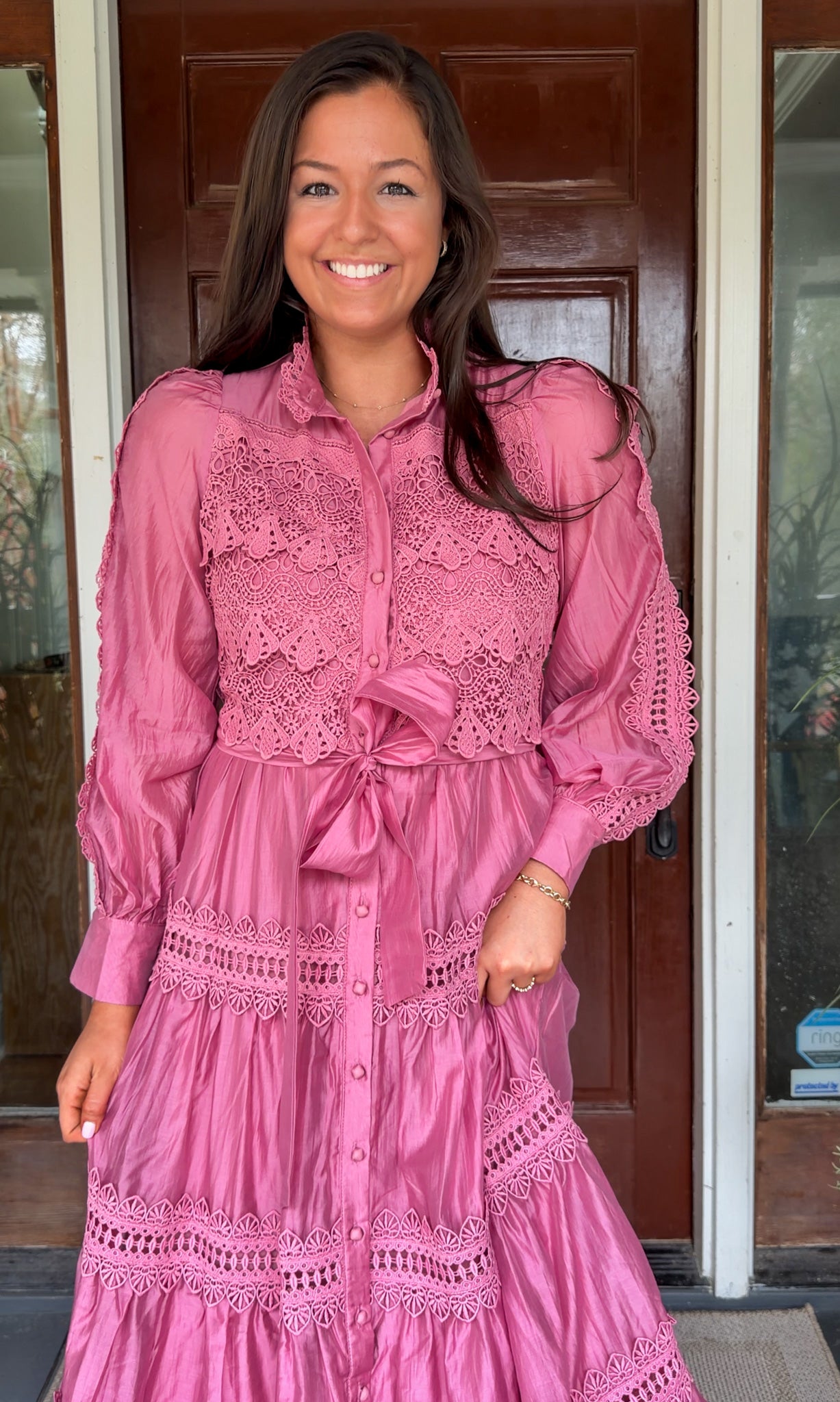 a satin midi dress with crochet lace panels, button-down front, long sleeves, and a self-tie waist in a soft plum color. pink mauve high neck