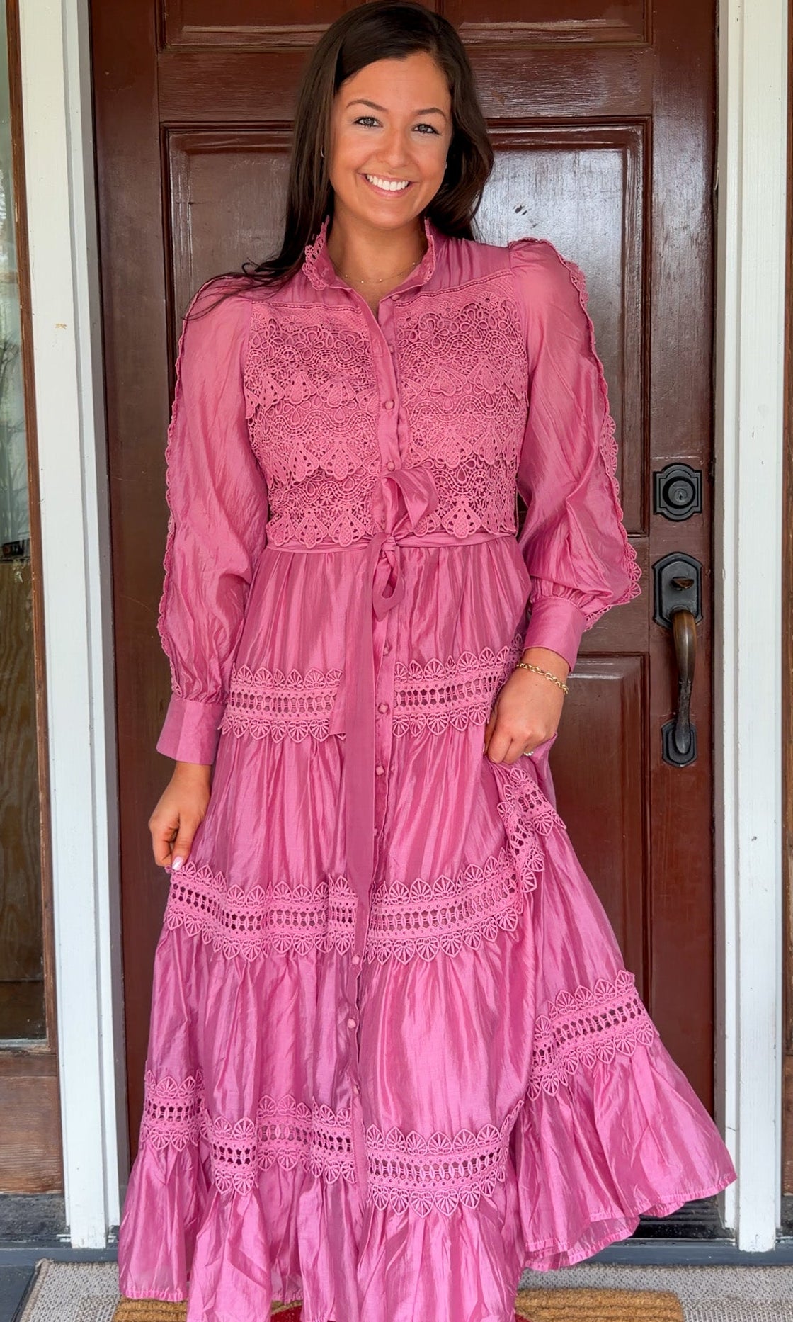 a satin midi dress with crochet lace panels, button-down front, long sleeves, and a self-tie waist in a soft plum color. pink mauve high neck