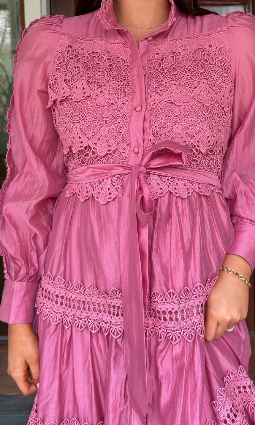 a satin midi dress with crochet lace panels, button-down front, long sleeves, and a self-tie waist in a soft plum color. pink mauve high neck
